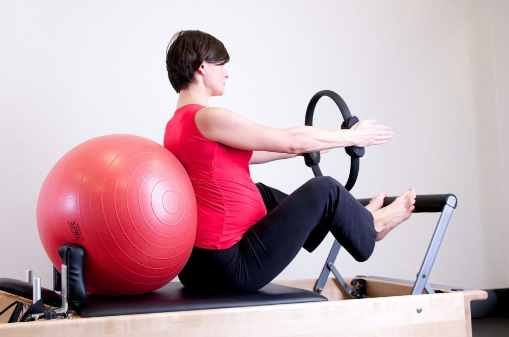 woman-in-red-top-leaning-on-red-stability-ball-1103254